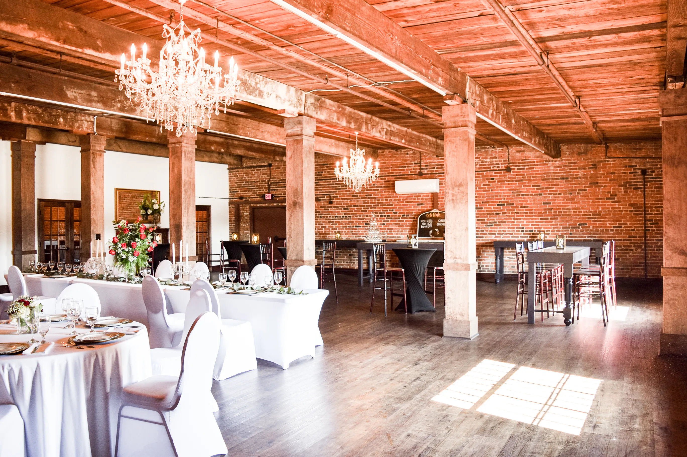 Dining tables and cocktail tables arranged across The Cotton Loft event room