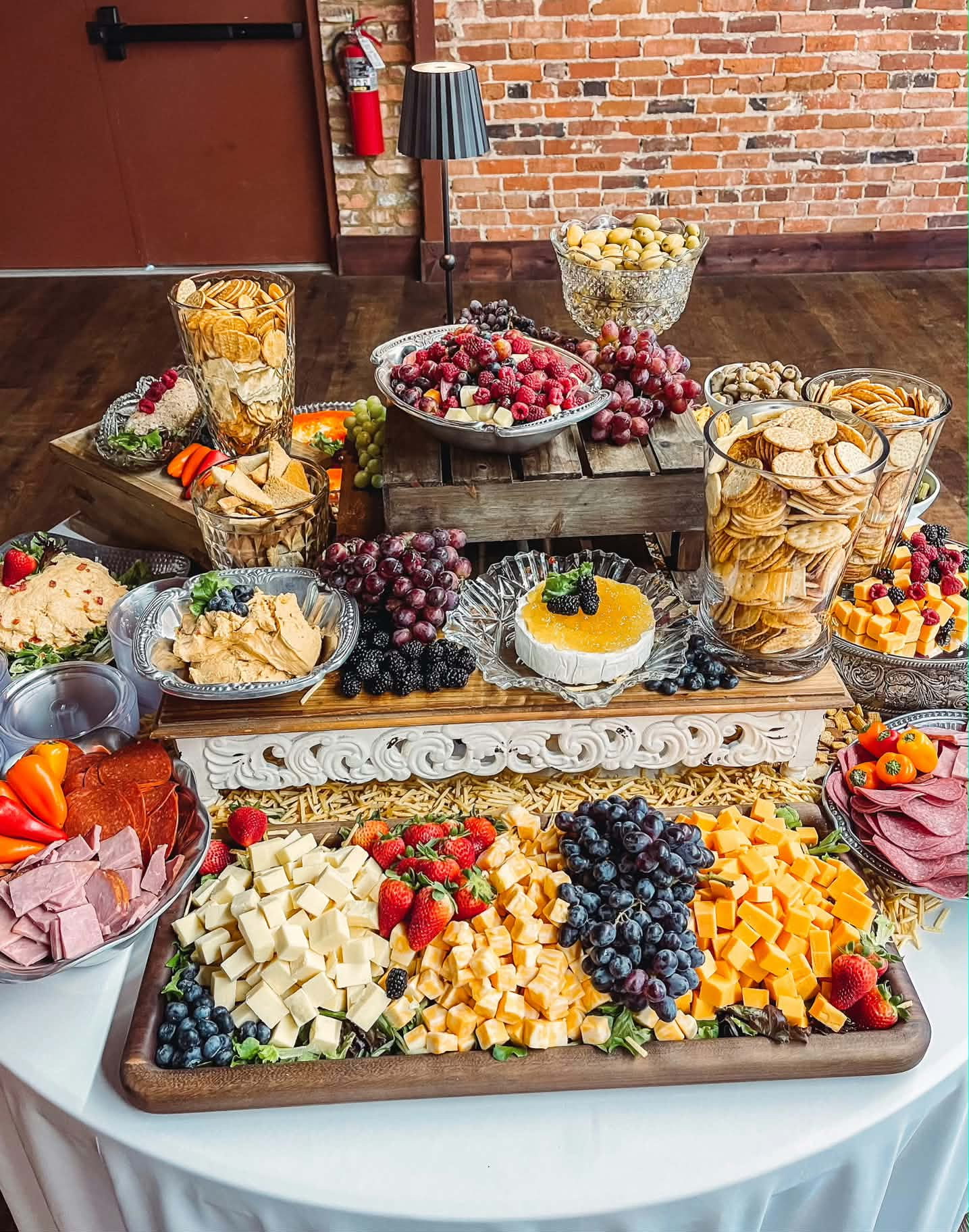 Grazing table with cheeses, fruit, breads, and desserts